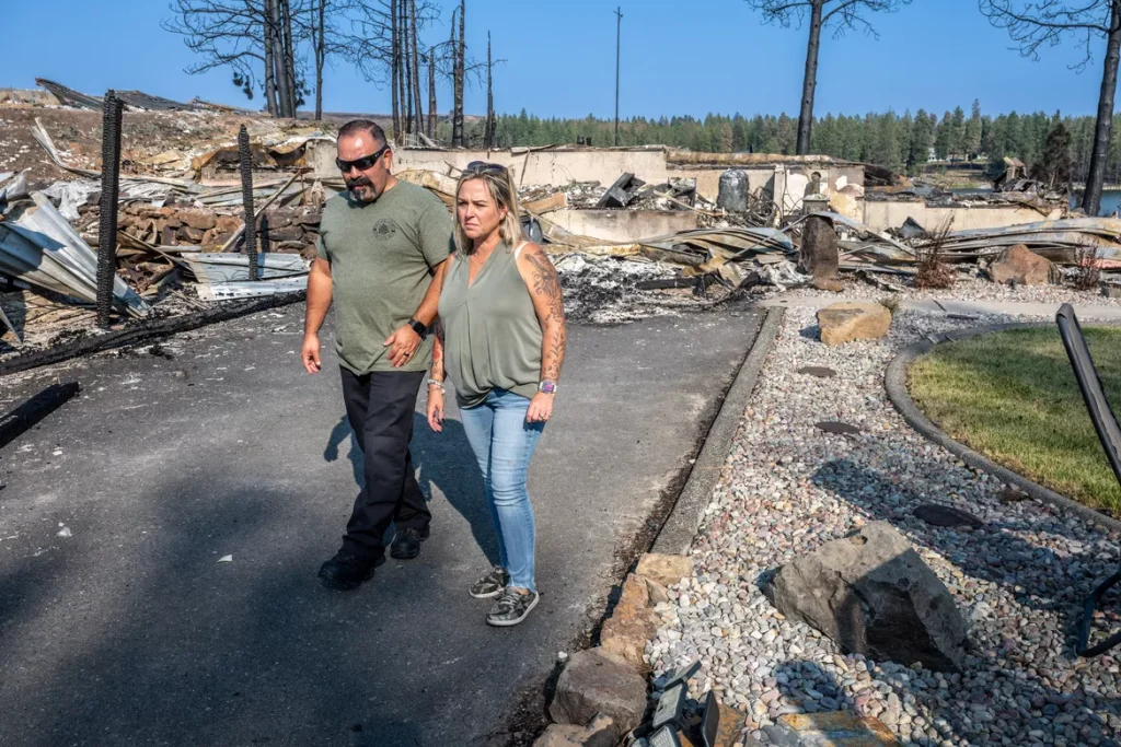 A couple walks through the wreckage of their home, destroyed by The Grey Fire.